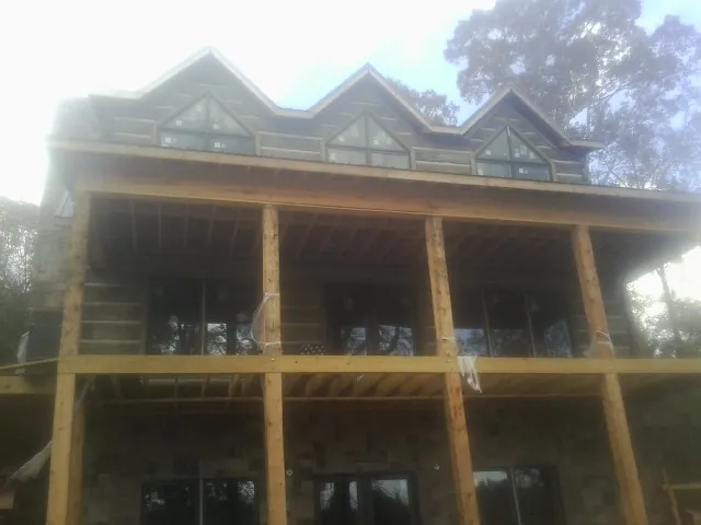 Dormers and porch framing on a large log home under construction — Roof Coating work by our crew in West Hollywood